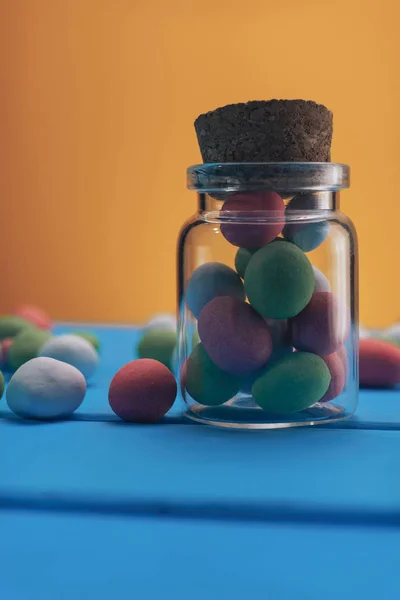Pequena Garrafa Amendoins Multicoloridos Chocolate Cobertura Mesa Madeira Azul Fundo — Fotografia de Stock