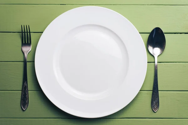 White Plate Fork Spoon Green Wooden Table Background — 스톡 사진