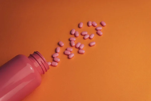 Beautiful Pink Bottle Pink Pills Orange Background Top View — Stock Photo, Image