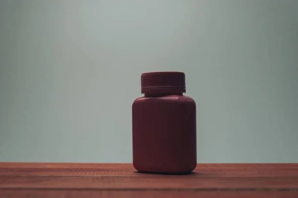 Botella Rosa Para Pastillas Sobre Una Mesa Madera Roja Fondo — Foto de Stock