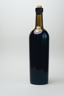 Eski bir meşe ahşap masa ve gri arka plan üzerinde kırmızı şarap Şişesi.