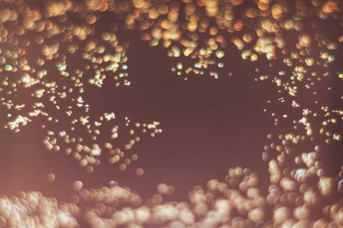 Kahverengi bir arka plan üzerinde güzel altın bokeh.