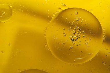 Sarı bir arka plan üzerinde güzel karıştırma su ve yağ.