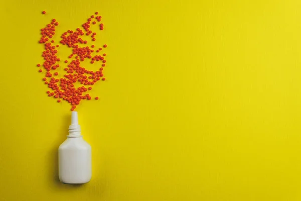White nose spray with particle aerosol spray made by red preparations on a yellow background.