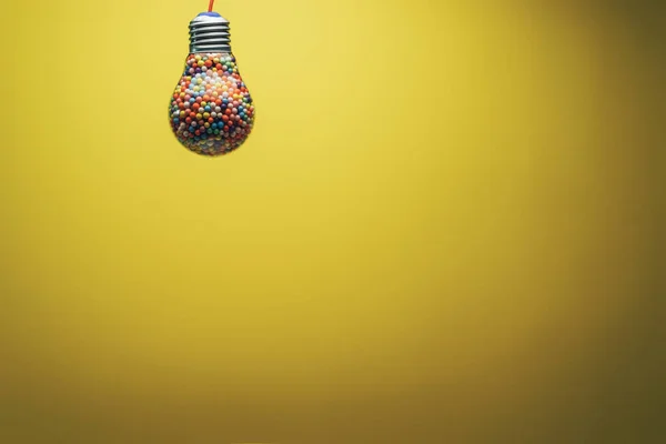 Bombilla Creativa Llena Bola Multicolor Sobre Fondo Amarillo Detrás Concepto —  Fotos de Stock