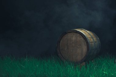 Old woden barrel in grass on a dark background. clipart