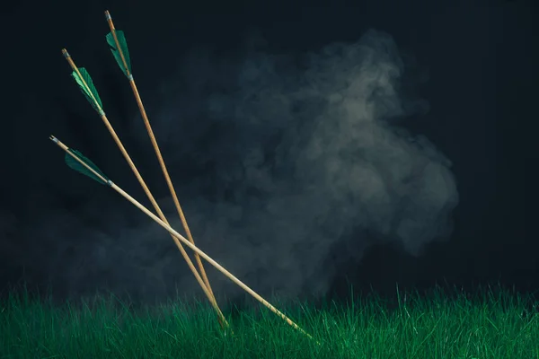 草地上有三个木箭 美丽的烟雾背景 中世纪手工制造武器 — 图库照片
