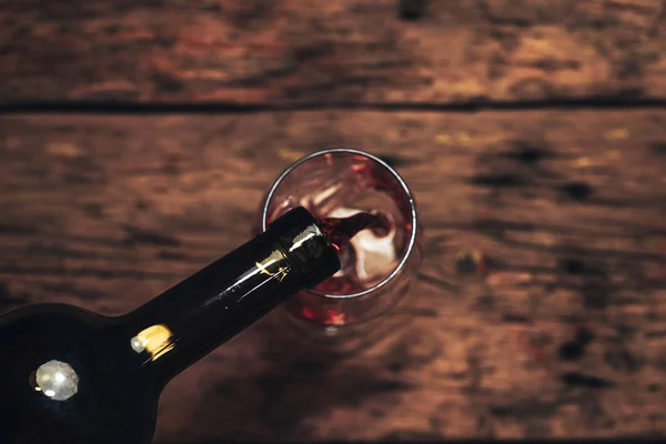 Versare Bottiglia Vino Rosso Bicchiere Vino Vecchio Tavolo Legno — Foto Stock