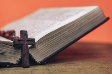 Eski kırmızı boncuklar ve İncil'de haç. Güzel Coral Orange arka plan. Din kavramı.