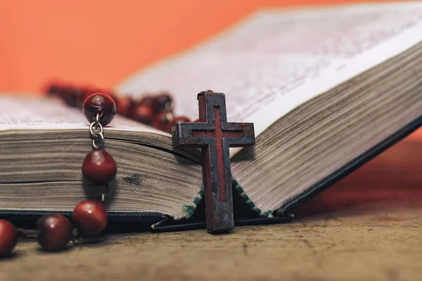 Eski kırmızı boncuklar ve İncil'de haç. Güzel Coral Orange arka plan. Din kavramı.