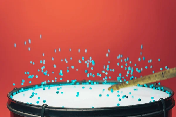 Colored balls bounces off drum in shockwave pattern. Beautiful red background.
