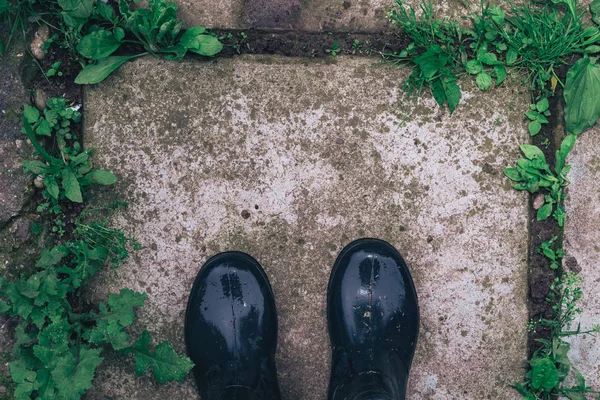 Boots from the first person on a  green background.