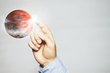 Beyaz bir arka plan üzerinde Yeni Ev Mars'a dokunan insan. Karışık ortam.