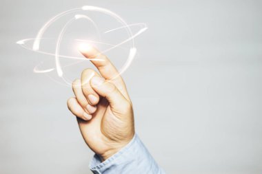 İnsan işaret parmağı sarı atom dokunur. Karışık teknik.
