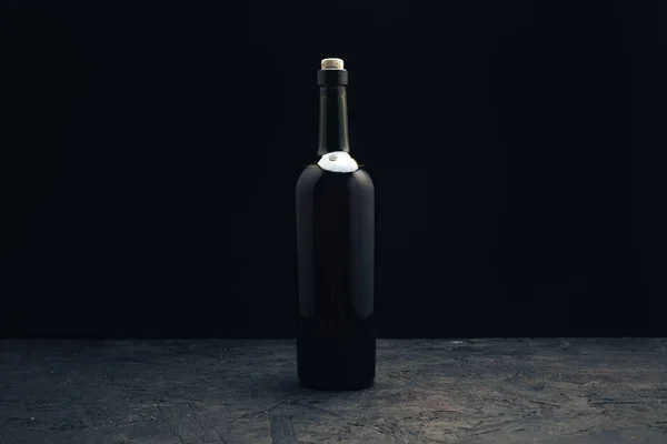 暗い木製のテーブルの上に赤ワインのボトル黒い背景ベハイド — ストック写真