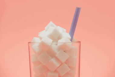 Güzel bir şeftali arka plan üzerinde saman ile küp şeker dolu Cam kapatın - sağlıksız diyet kavramı.