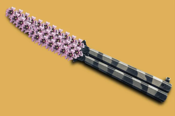 钢蝴蝶刀与紫色花在黄色创意背景 — 图库照片
