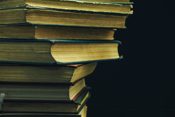 Close up Old books on a  table black background.