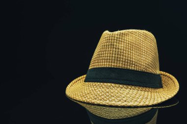 Siyah cam masa arka planda hasır şapka.