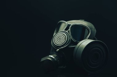 Siyah masa ve koyu arka plan üzerinde gaz maskesi. 