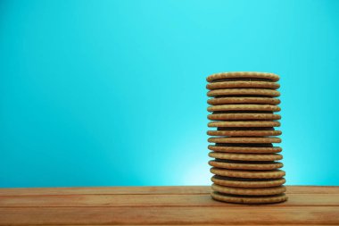 Çerez sandviç ared ahşap masa, mavi arka plan. 