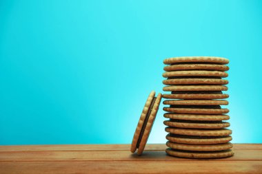 Çerez sandviç ared ahşap masa, mavi arka plan. 