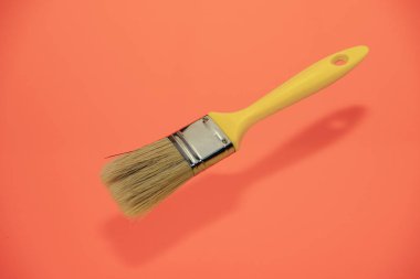 Yaşayan bir mercan arka plan üzerinde yeni sarı boya fırçası.