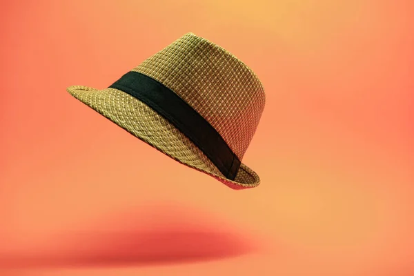 Beautiful straw hat on a peach background.