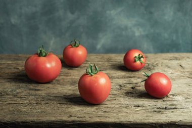 Eski bir meşe ahşap masa, güzel gri duvar arka plan taze domates kapatın.