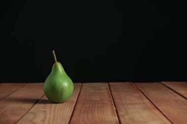 Kırmızı ahşap masa üzerinde taze yeşil armut, güzel siyah arka plan.