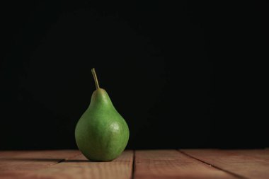 Kırmızı ahşap masa üzerinde taze yeşil armut, güzel siyah arka plan.