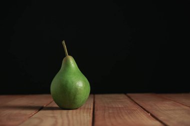 Kırmızı ahşap masa üzerinde taze yeşil armut, güzel siyah arka plan.