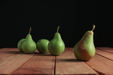 Kırmızı ahşap masa, güzel siyah arka plan üzerinde taze yeşil armut kapatın.