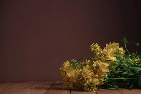 Gele Bloemen Een Rode Houten Tafel Mooie Donker Rode Muur — Stockfoto