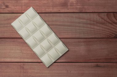 Kırmızı ahşap masa arka plan üzerinde beyaz çikolata.