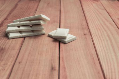 Kırmızı ahşap masa arka plan üzerinde beyaz çikolata.