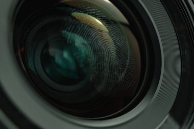 Kamera objektifi arka planında parmak izini kapatın. Makro görünümü.