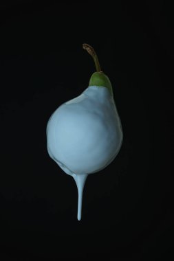 Siyah bir arka planda beyaz boya damlayan güzel taze armut. Yaratıcı poster.