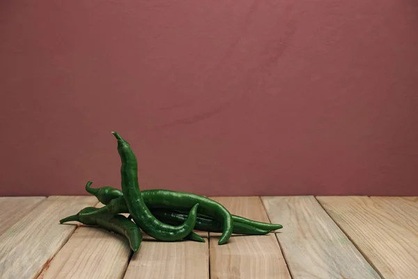 Schöne Frische Grüne Paprika Auf Einem Holztisch Und Roten Wandhintergrund — Stockfoto