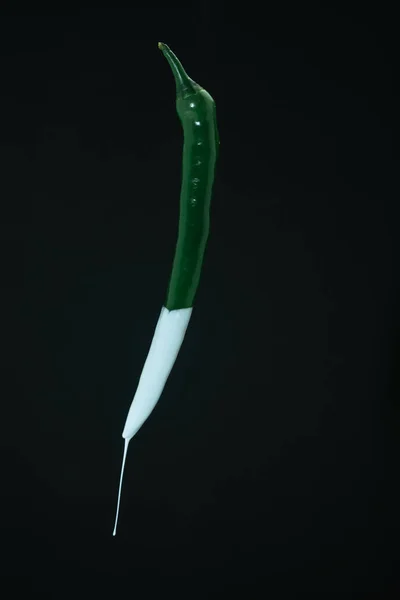 Tropfende Weiße Farbe Von Frischem Grünen Pfeffer Auf Schwarzem Hintergrund — Stockfoto