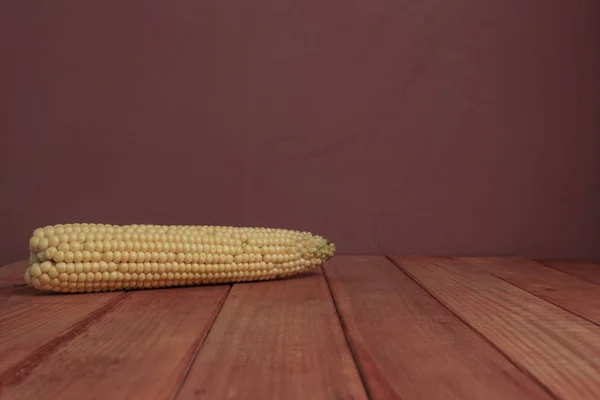 Frisches Zuckermais Auf Einem Roten Holztisch Und Schönen Roten Wandhintergrund — Stockfoto