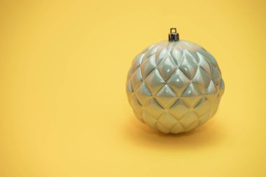 Güzel noel gümüş bauble sarı bir arka plan üzerinde yakın.