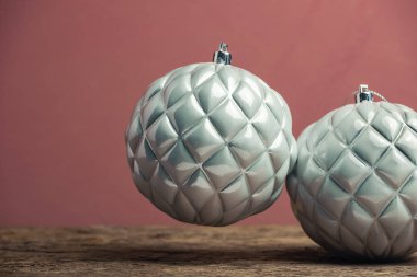 Eski bir ahşap tble ve kırmızı duvar arka plan üzerinde güzel noel gümüş bauble.