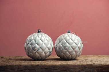 Eski bir ahşap tble ve kırmızı duvar arka plan üzerinde güzel noel gümüş bauble.