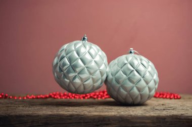 Eski bir ahşap tble ve kırmızı duvar arka plan üzerinde güzel noel gümüş bauble.