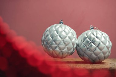 Eski bir ahşap tble ve kırmızı duvar arka plan üzerinde güzel noel gümüş bauble.