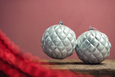 Eski bir ahşap tble ve kırmızı duvar arka plan üzerinde güzel noel gümüş bauble.