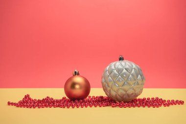 Güzel noel gümüş baubles ve boncuklar sarı, kırmızı arka plan üzerinde yakın.