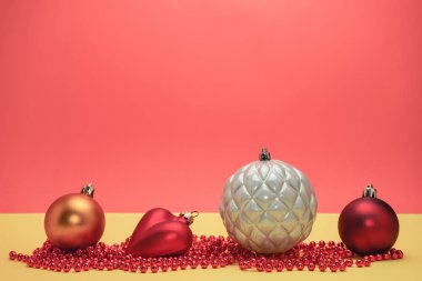 Güzel noel gümüş baubles ve boncuklar sarı, kırmızı arka plan üzerinde yakın.