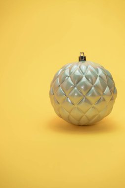 Güzel noel gümüş bauble sarı bir arka plan üzerinde yakın.